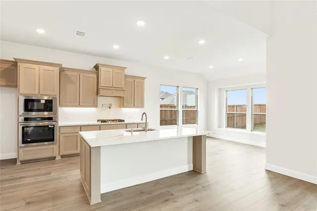 a large kitchen with stainless steel appliances granite countertop a stove and a sink