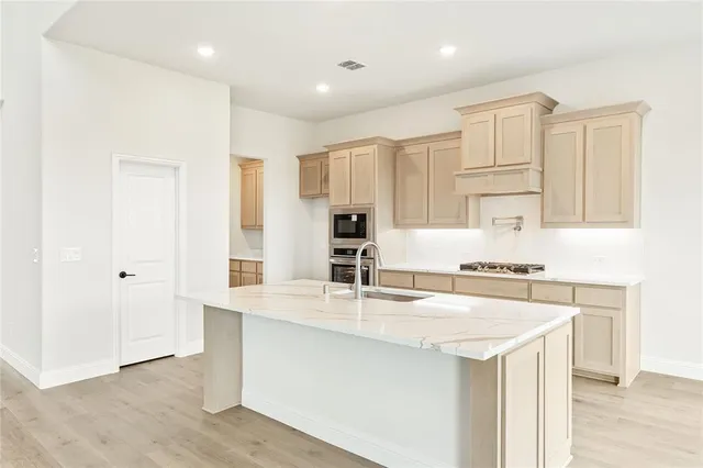 a kitchen with kitchen island a sink stove and white cabinets