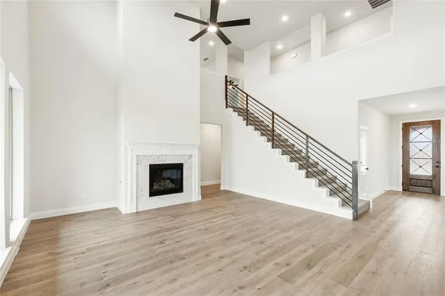 a view of a livingroom with wooden floor a fireplace and windows