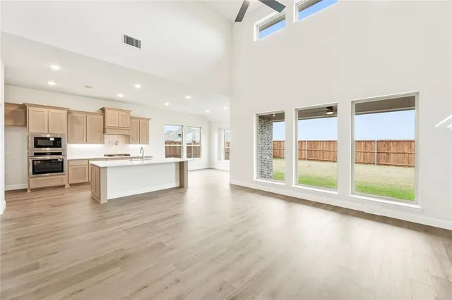 a view of kitchen with kitchen island wooden floor and refrigerator