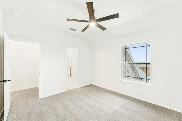 an empty room with a ceiling fan and a window