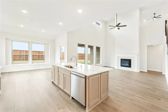 a open kitchen with stainless steel appliances granite countertop a stove and a white cabinets