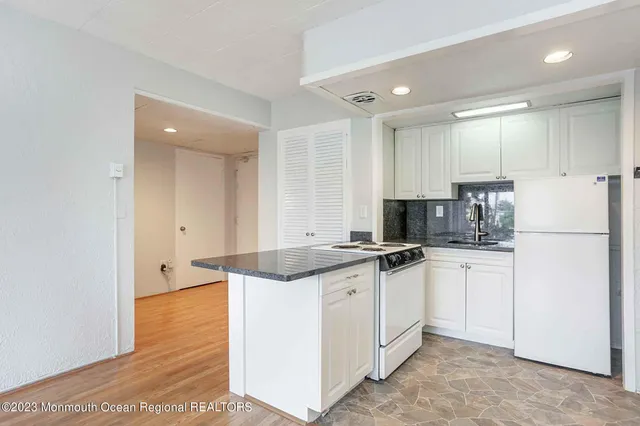 a kitchen with granite countertop a sink and cabinets