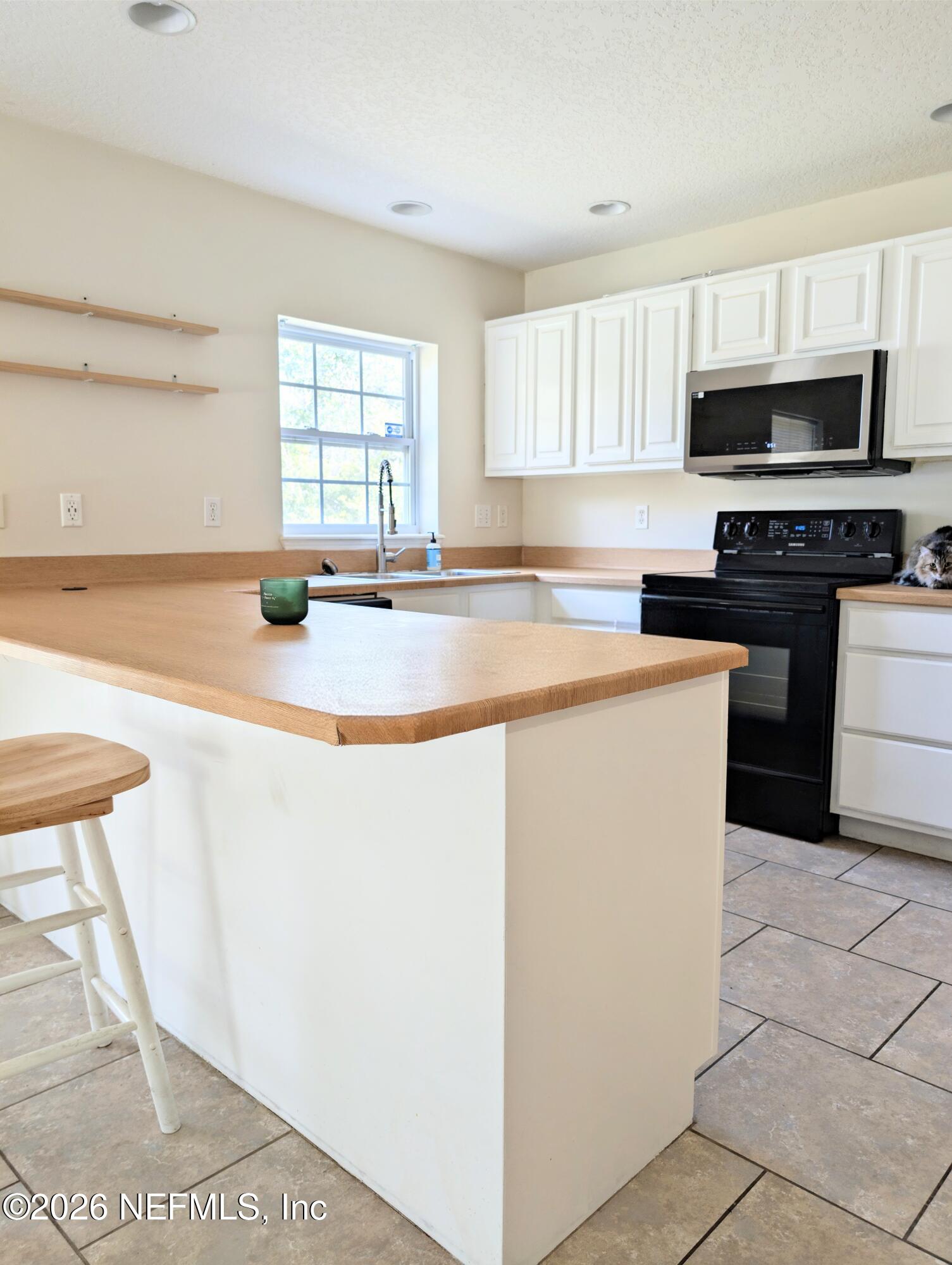 7 Arthur Street St. Augustine, FL 32084 - Photo 12 of 30 a kitchen with stainless steel appliances a stove a sink and a microwave