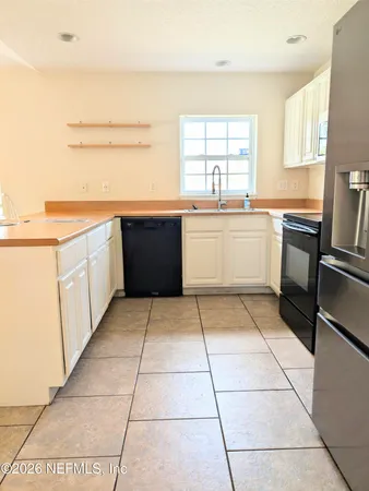 a large kitchen with a stove a sink dishwasher and a refrigerator