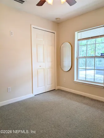 an empty room with windows and closet