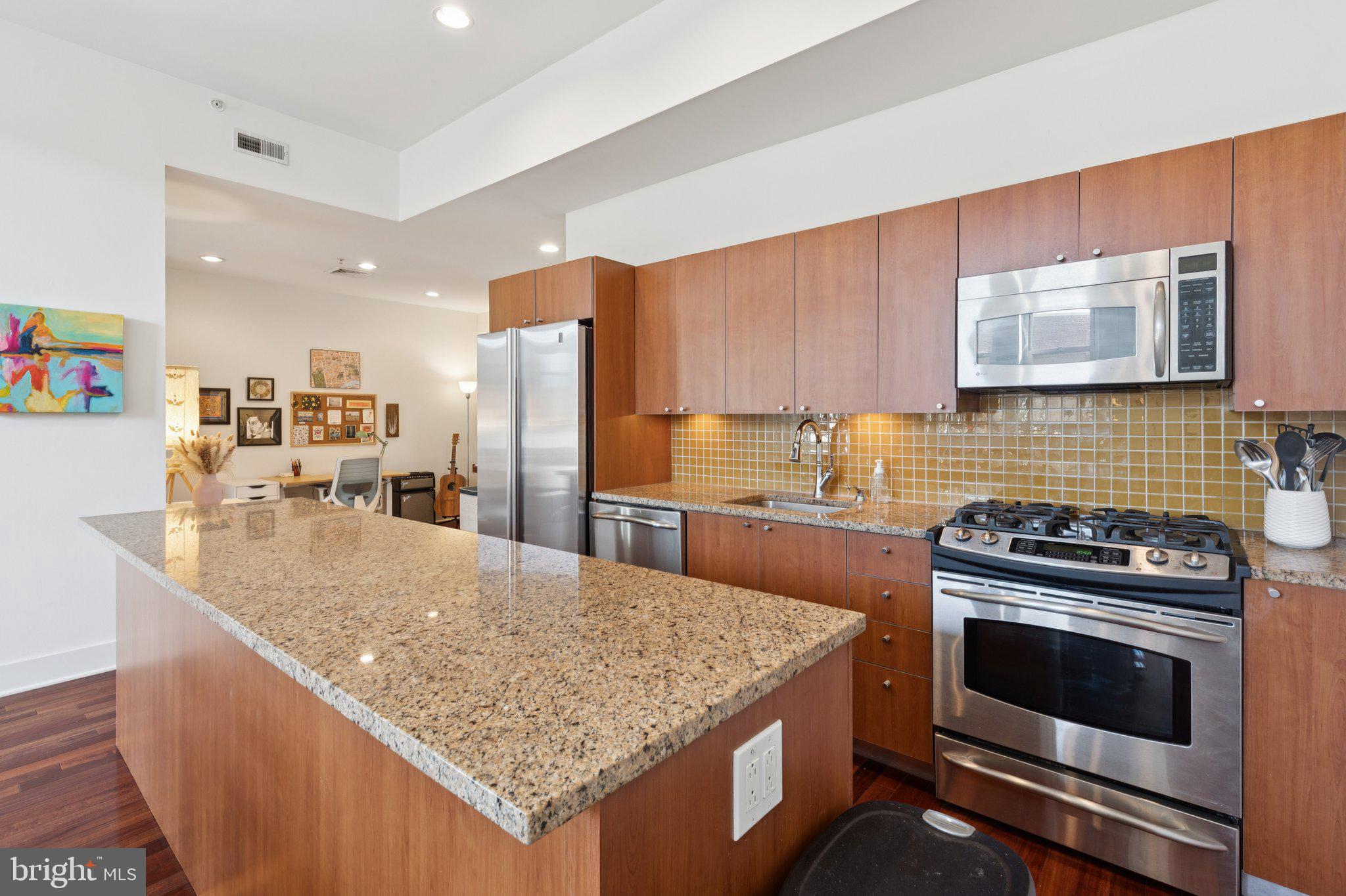 1101 Locust Street, Unit 3C Philadelphia, PA 19107 - Photo 11 of 28 a kitchen with granite countertop a sink stove and refrigerator