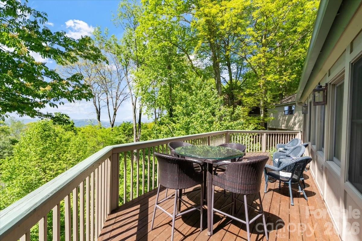 121 Ivy Ridge Road Burnsville, NC 28714 - Photo 25 of 48 a balcony with wooden floor table and chairs