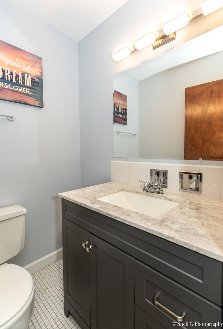 9745 Karlov Avenue, Unit 607 Oak Lawn, IL 60453 - Photo 16 of 16 a bathroom with a granite countertop toilet sink and mirror