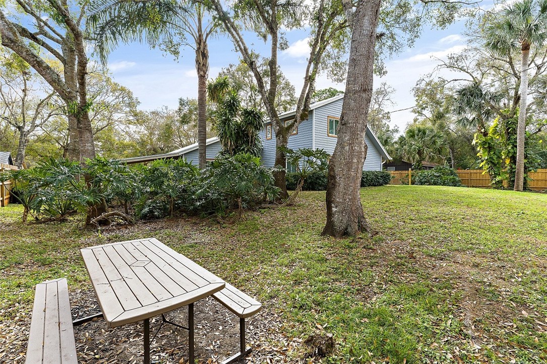 6366 5th Street Vero Beach, FL 32968 - Photo 3 of 36 a view of a backyard with table and chairs plants and large trees