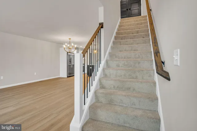 a view of a hallway with wooden floor and stairs