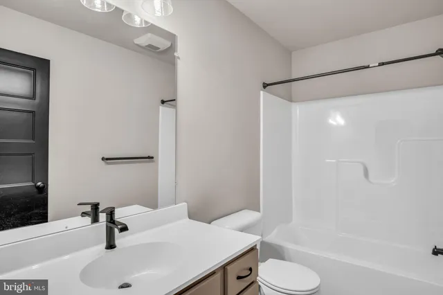 a bathroom with a sink toilet a mirror and shower