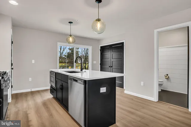 a kitchen with a stove and wooden floor