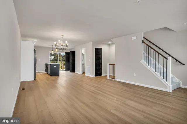 a view of a big room with wooden floor and a kitchen