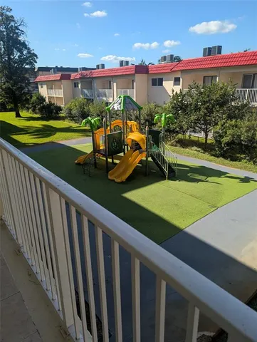 a view of a house with a yard and table and chairs under an umbrella