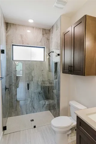 a bathroom with a sink a toilet and shower