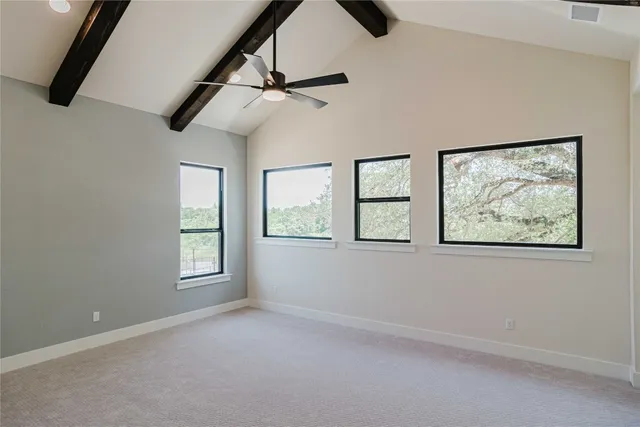 an empty room with windows and fan
