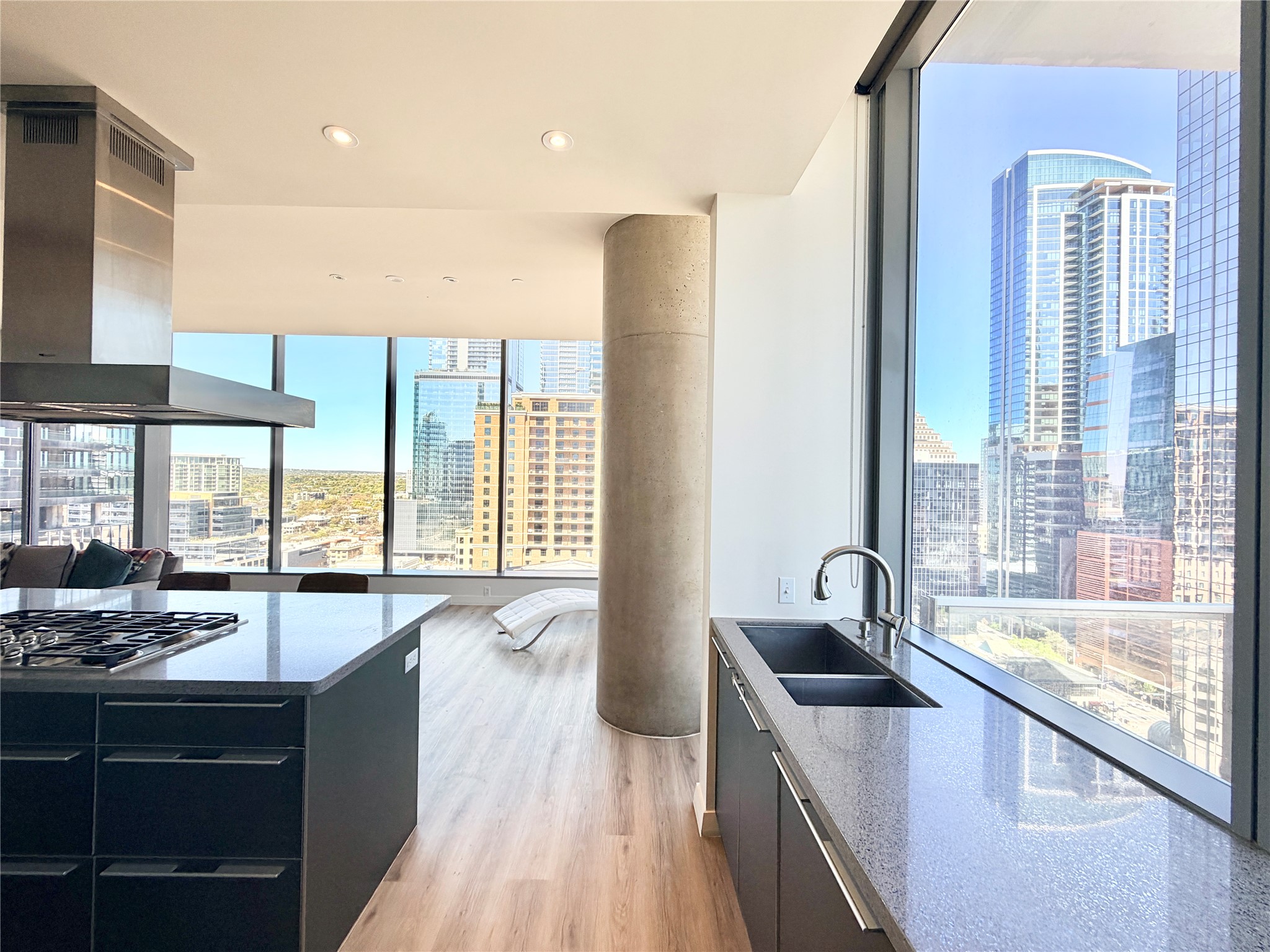 210 Lavaca Street, Unit 1912 Austin, TX 78701 - Photo 21 of 40 Kitchen with a view of city, dark cabinets, exhaust hood, dark stone counters, and recessed lighting