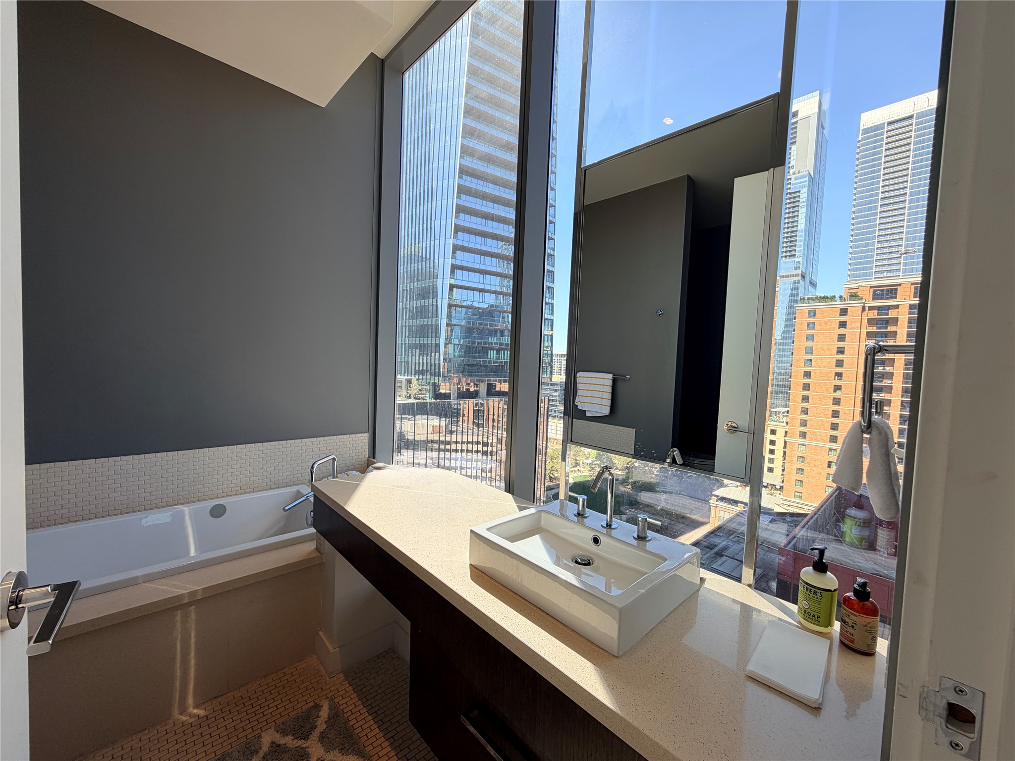 210 Lavaca Street, Unit 1912 Austin, TX 78701 - Photo 28 of 40 Bathroom featuring vanity, a garden tub, a view of city, and plenty of natural light