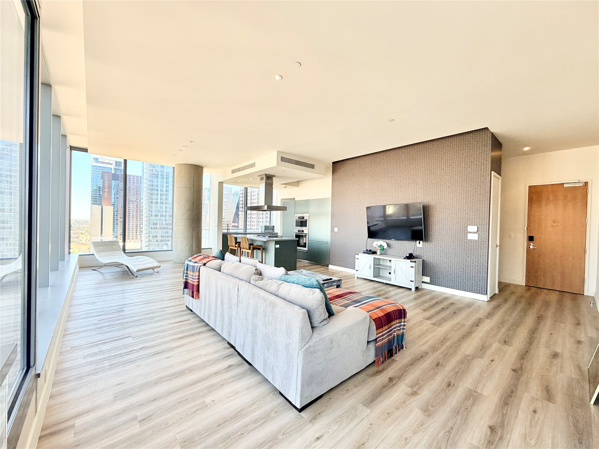 210 Lavaca Street, Unit 1912 Austin, TX 78701 - Photo 5 of 40 Living room with light wood-style floors, expansive windows, and an accent wall