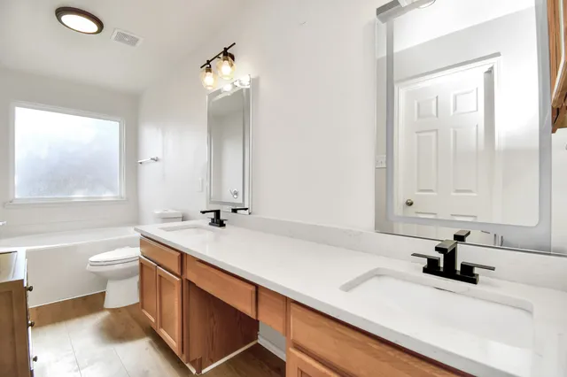 a bathroom with a sink double vanity and a toilet