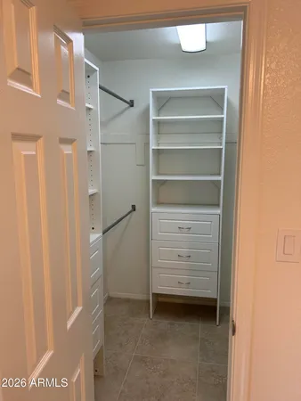 a view of wooden floor and a chandelier fan in a room