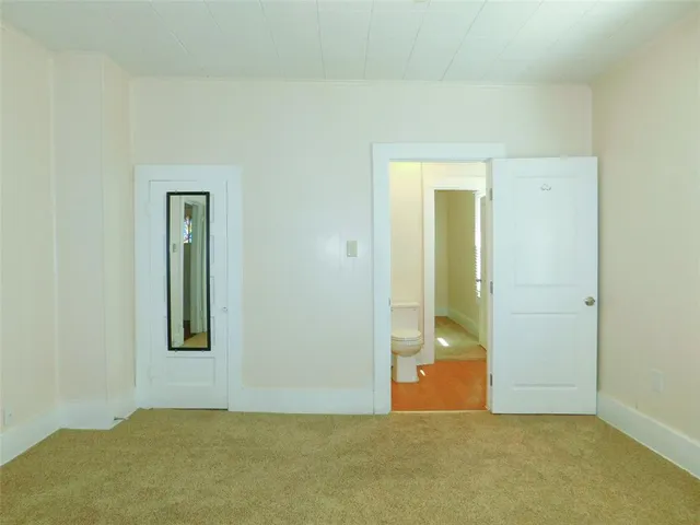 a view of a big room with wooden floor and windows