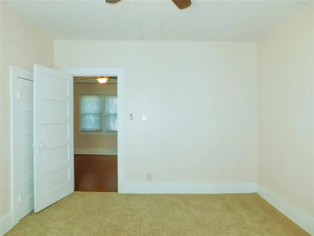 an empty room with closet and chandelier fan