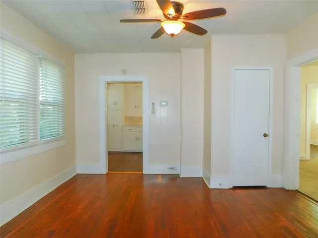 a view of an empty room with chandelier fan and fire place