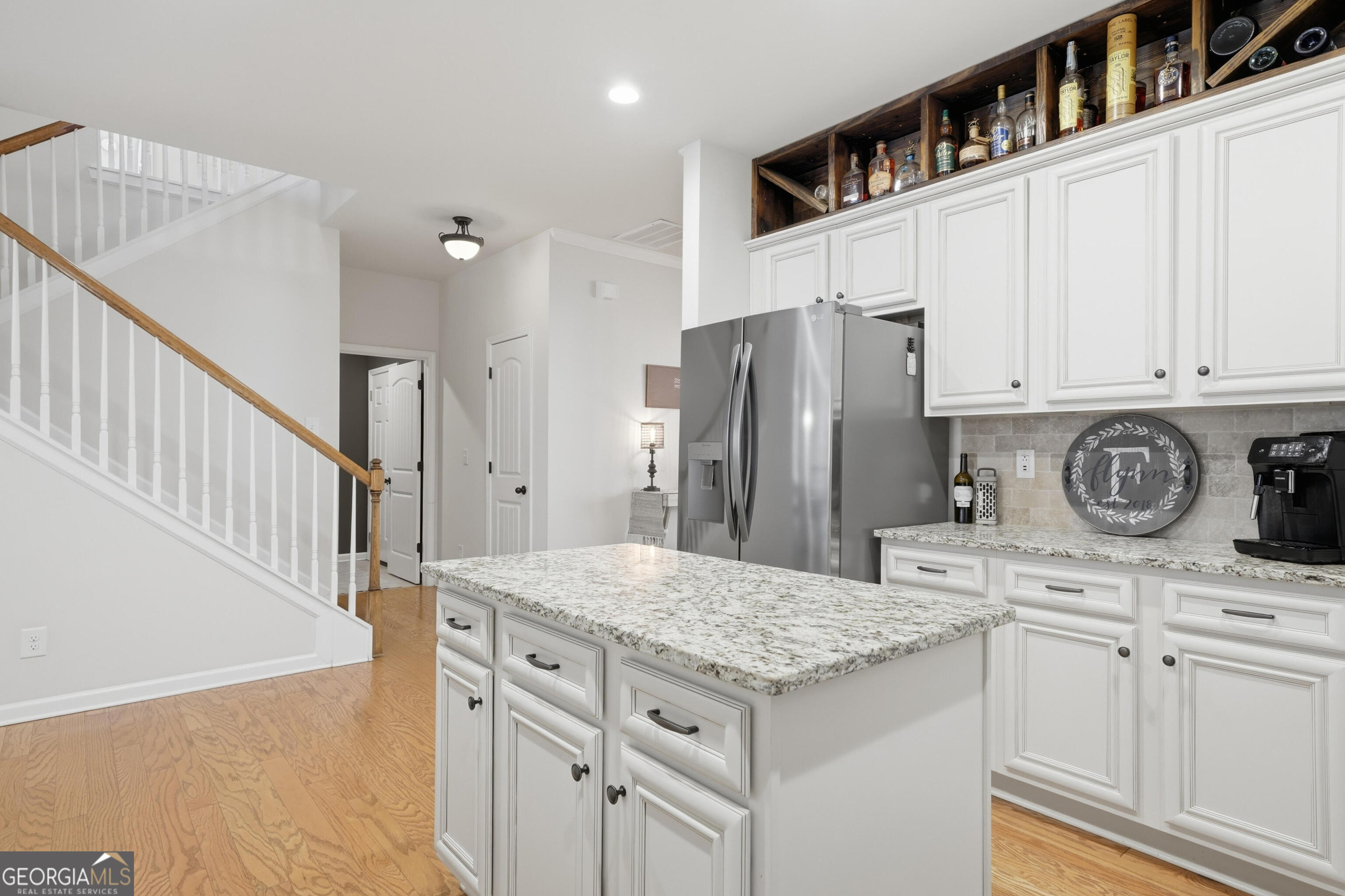 301 Stoney Hollow Road Canton, GA 30114 - Photo 21 of 47 a kitchen with granite countertop a refrigerator a stove and white cabinets with wooden floor