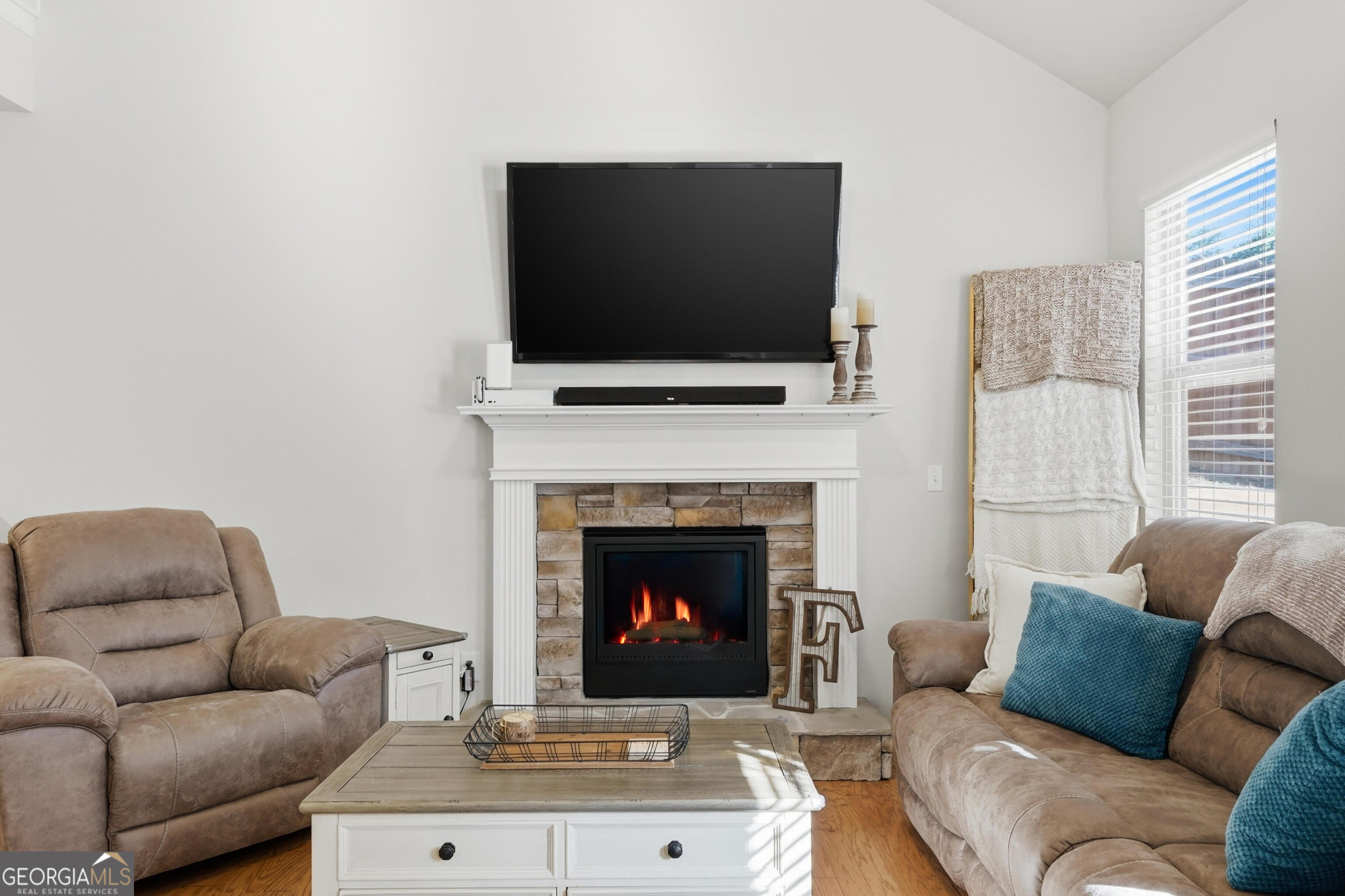 301 Stoney Hollow Road Canton, GA 30114 - Photo 24 of 47 a living room with furniture a flat screen tv and a fireplace