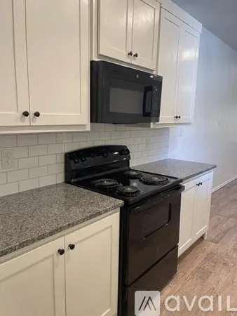 a kitchen with granite countertop cabinets and black appliances