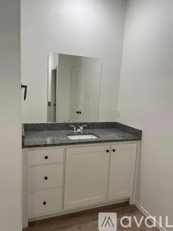 a view of a granite countertop white cabinets and a stove