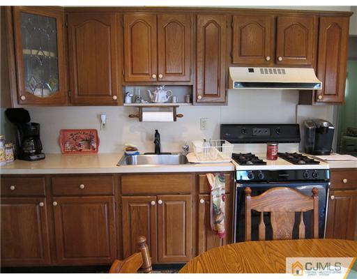 22 Fairfax Road Edison, NJ 08817 - Photo 3 of 8 a kitchen with stainless steel appliances granite countertop a stove a sink and dishwasher with wooden cabinets
