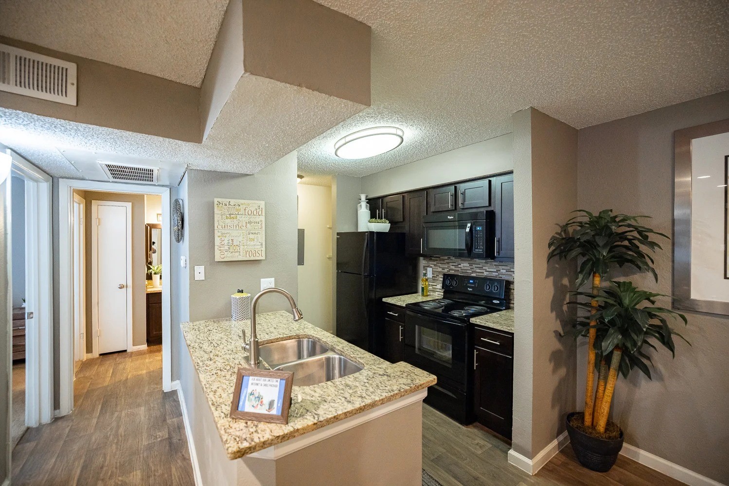 1773 Wells Branch Parkway, Unit 1018 Austin, TX 78728 - Photo 7 of 21 a kitchen with granite countertop a refrigerator stove and sink