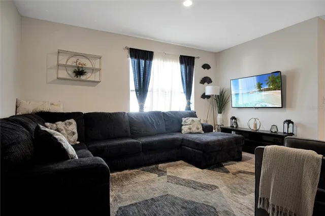a living room with furniture and kitchen view