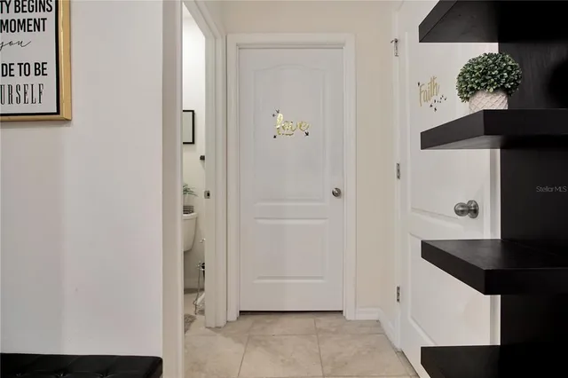 a bed sitting in a bedroom next to a window with tv and dresser
