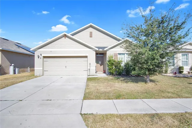 a view of house with garage and small yard
