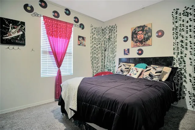 a bedroom with a bed and a painting on the wall