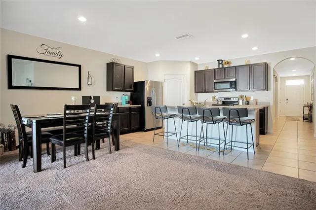 a living room with furniture kitchen view and a flat screen tv