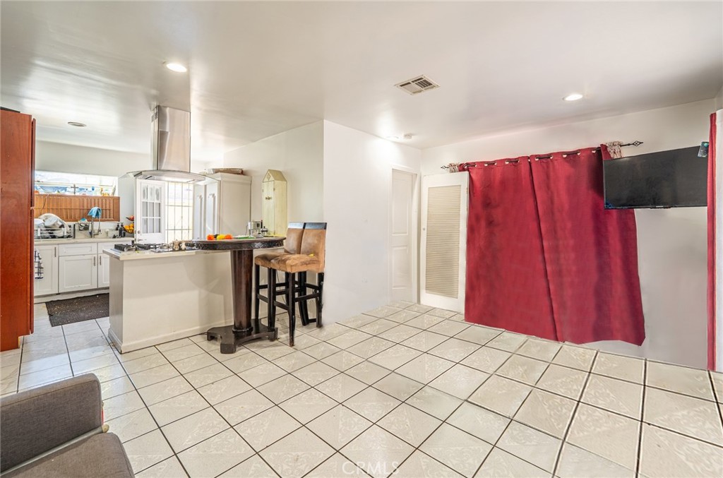 6824 Marcelle Street Paramount, CA 90723 - Photo 16 of 46 a kitchen with stainless steel appliances kitchen island granite countertop a refrigerator and a stove top oven