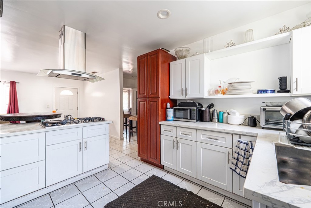 6824 Marcelle Street Paramount, CA 90723 - Photo 17 of 46 a kitchen with stainless steel appliances granite countertop a stove a sink and a refrigerator