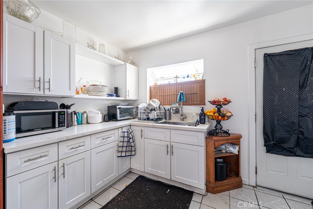 6824 Marcelle Street Paramount, CA 90723 - Photo 18 of 46 a kitchen with white cabinets and sink