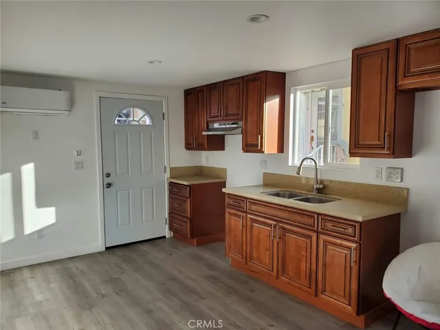 a view of an empty room with wooden floor and closet