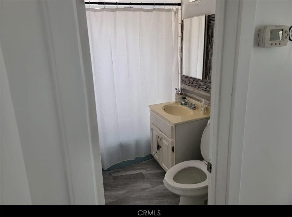 6824 Marcelle Street Paramount, CA 90723 - Photo 38 of 46 a bathroom with a toilet sink and mirror