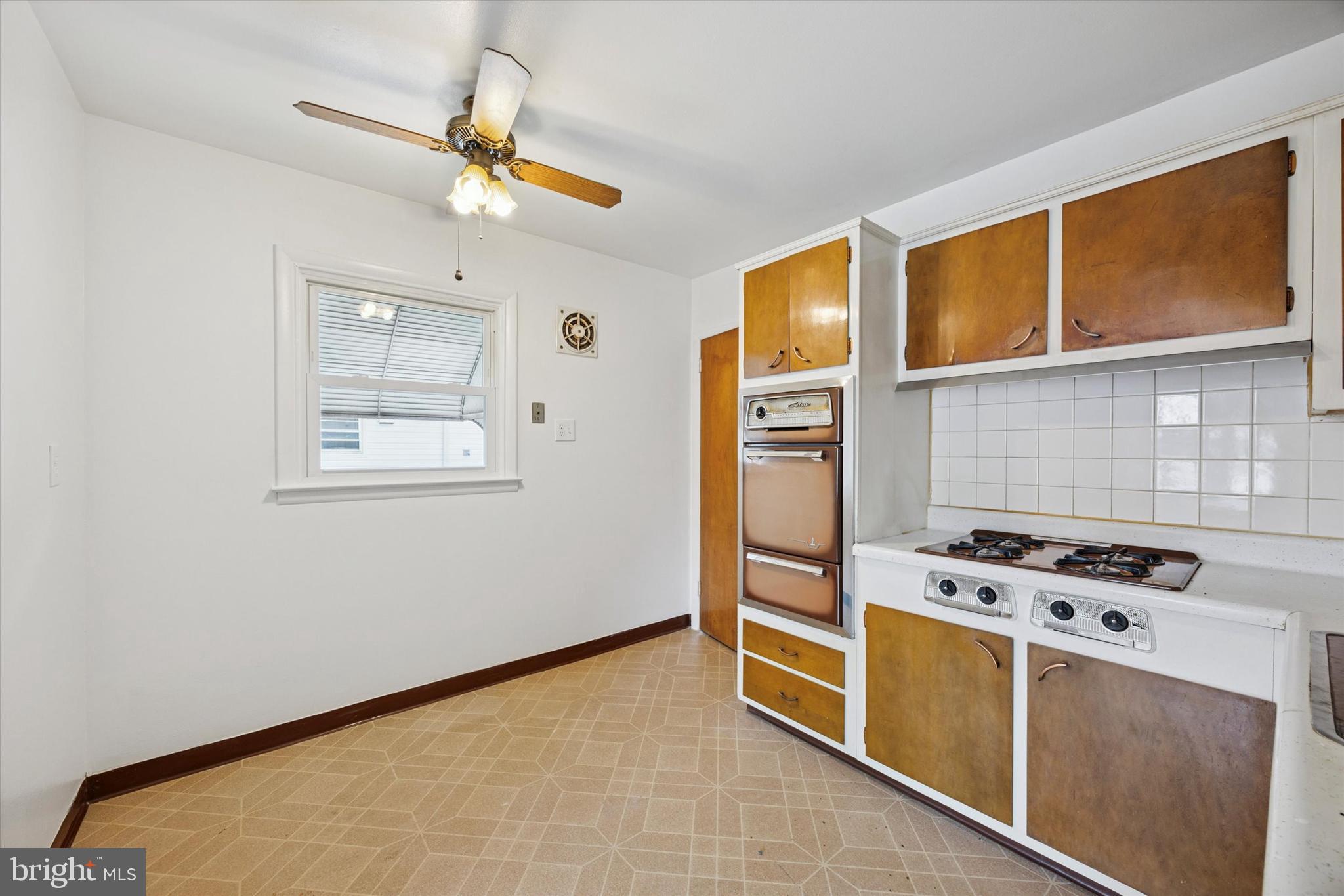 1069 Surrey Road Philadelphia, PA 19115 - Photo 11 of 27 a kitchen with stainless steel appliances a stove a sink and a refrigerator