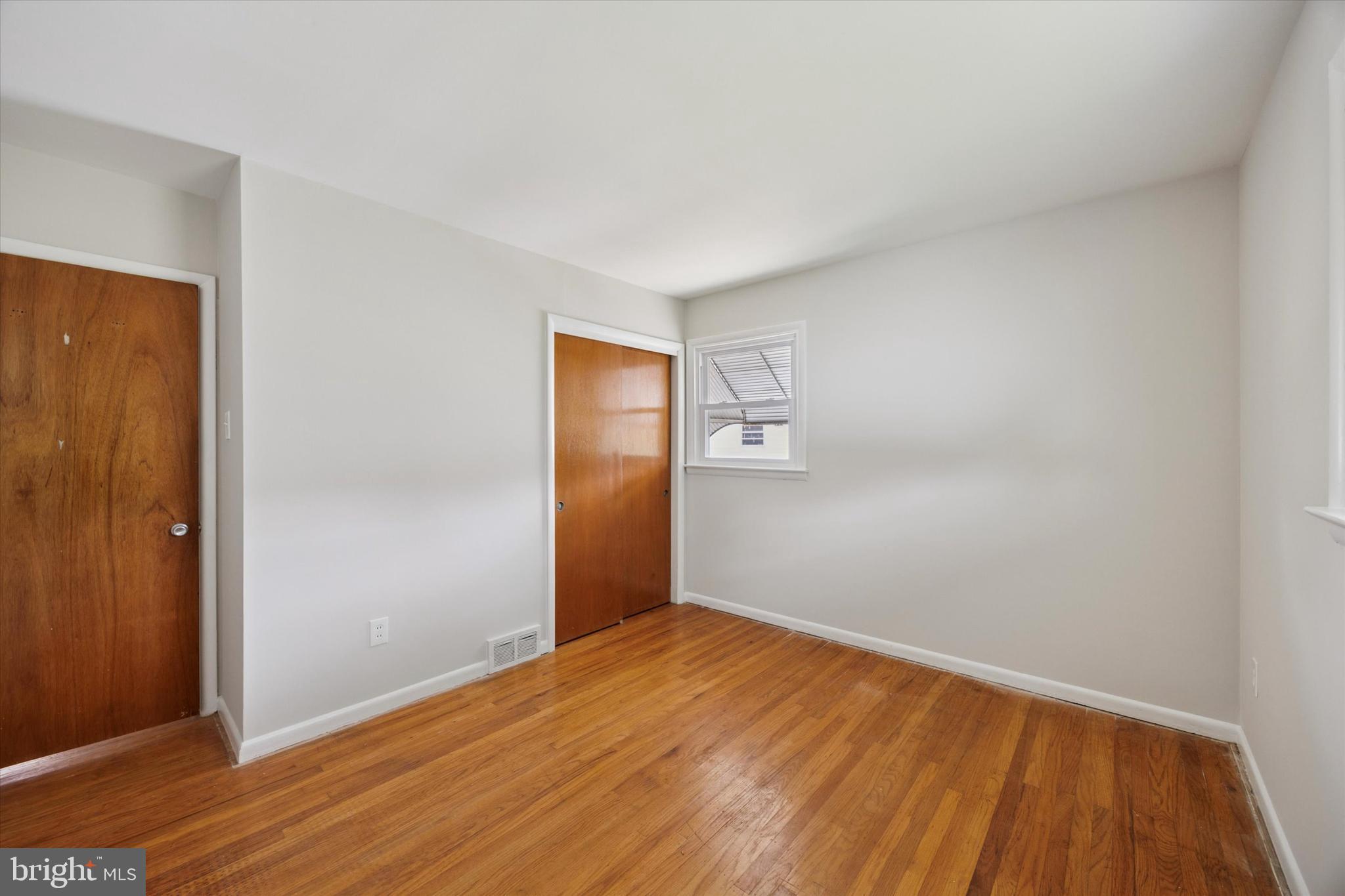 1069 Surrey Road Philadelphia, PA 19115 - Photo 21 of 27 an empty room with wooden floor and windows