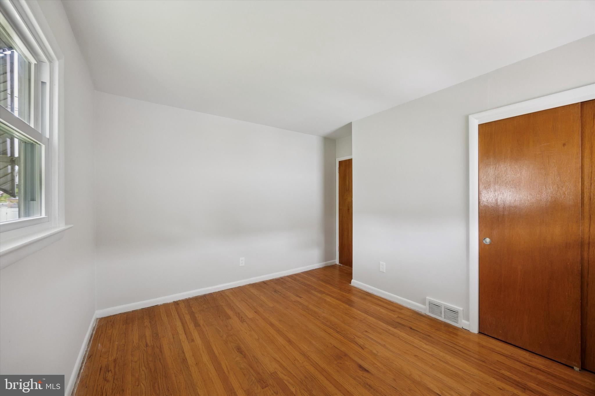 1069 Surrey Road Philadelphia, PA 19115 - Photo 22 of 27 an empty room with wooden floor and windows