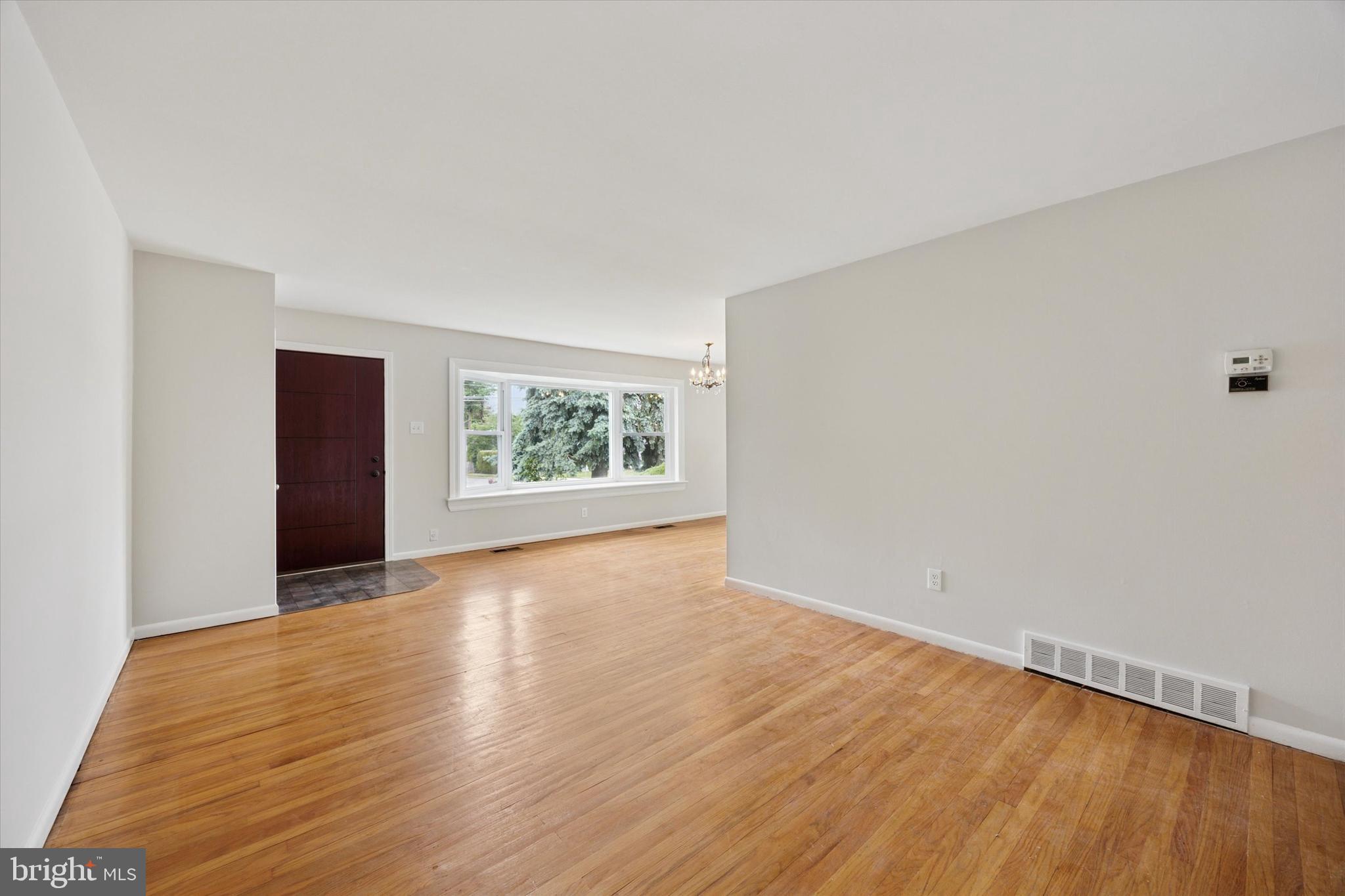 1069 Surrey Road Philadelphia, PA 19115 - Photo 5 of 27 an empty room with wooden floor and windows
