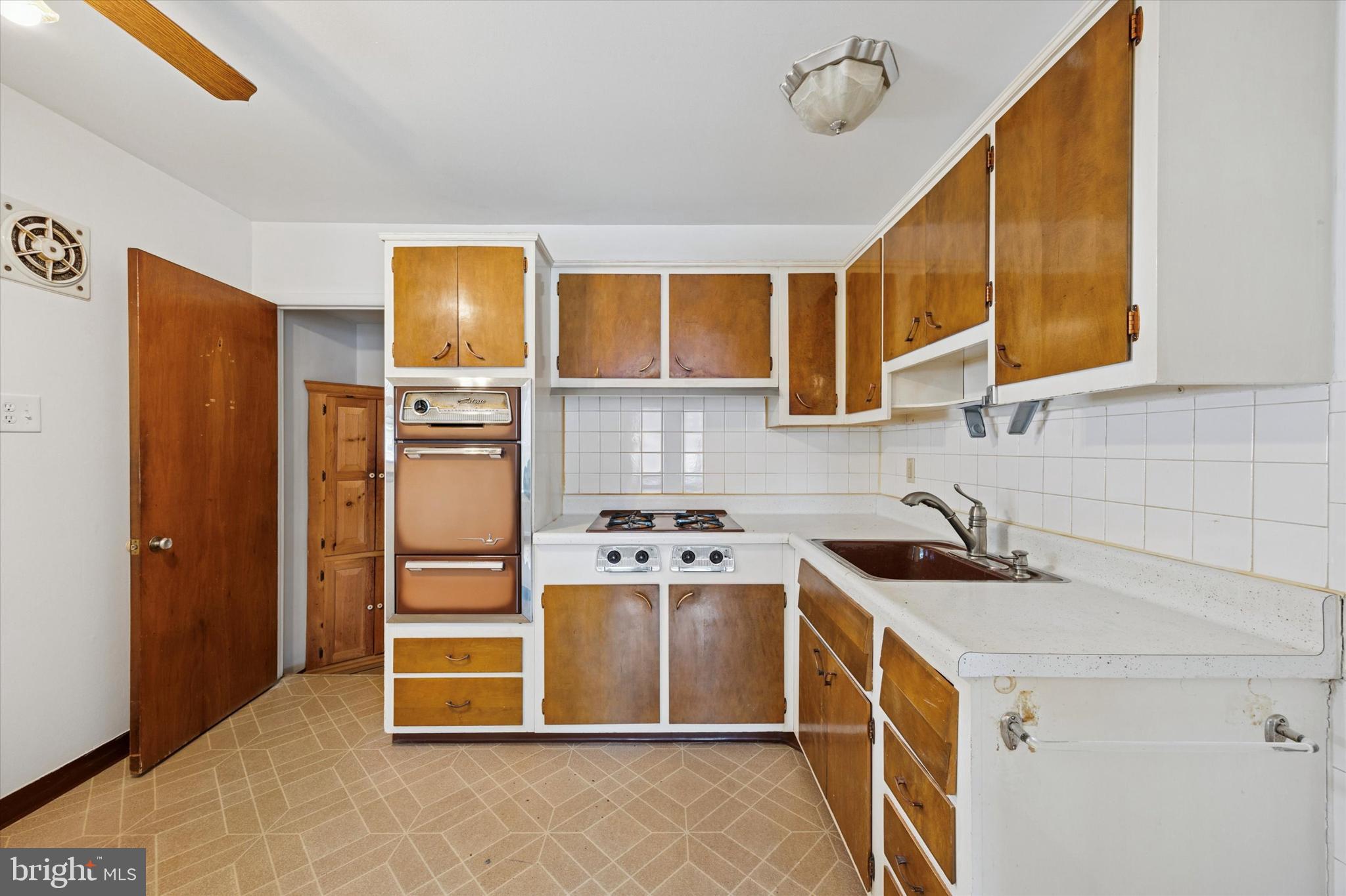 1069 Surrey Road Philadelphia, PA 19115 - Photo 9 of 27 a kitchen with stainless steel appliances a stove a sink and a refrigerator